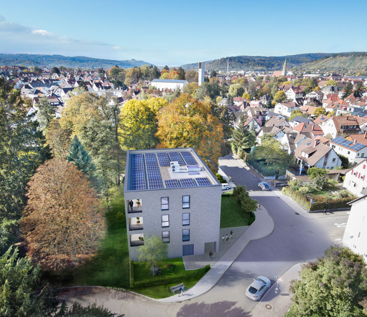 Löwenseestraße Luftaufnahme eines modernen SCHATZ Wohnbau-Gebäudes mit Solarmodulen auf dem Dach, umgeben von Bäumen und Häusern in einem Vorort von Schorndorf unter strahlend blauem Himmel – eine ideale Kulisse für alle, die eine Immobilie kaufen möchten.