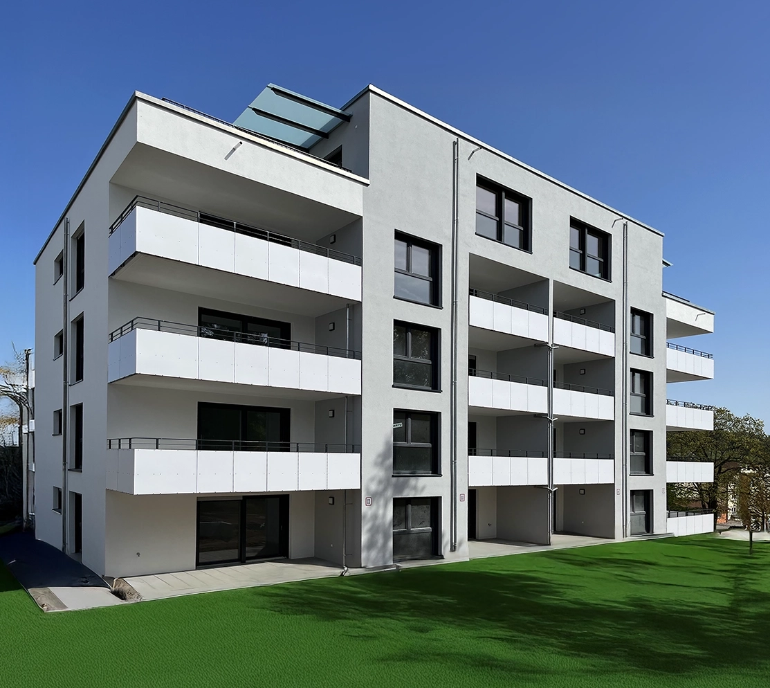 Bronnwiesenweg Rudersberg Modernes vierstöckiges Wohnhaus mit weißer Fassade, großen Balkonen und vielen Fenstern, umgeben von leuchtend grünem Rasen unter strahlend blauem Himmel – ideal für alle, die eine Wohnung in Schorndorf oder eine Immobilie in dieser attraktiven Lage kaufen möchten.
